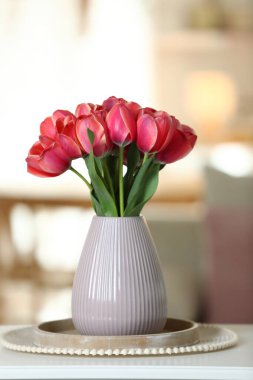 Beyaz masadaki vazodaki güzel laleler