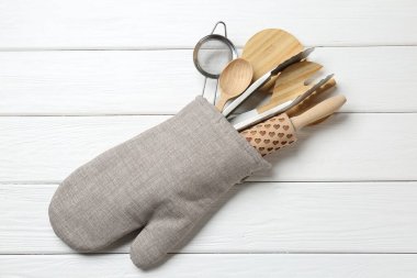 Farklı mutfak aletleri fırın eldiveni beyaz ahşap masa, üst görünüm