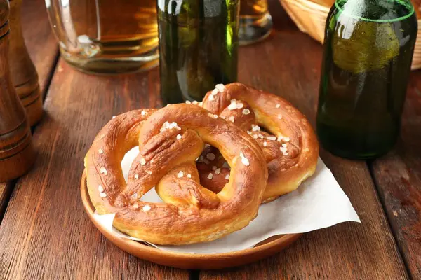 Lezzetli krakerler ve bira şişeleri ahşap masada, yakın plan.