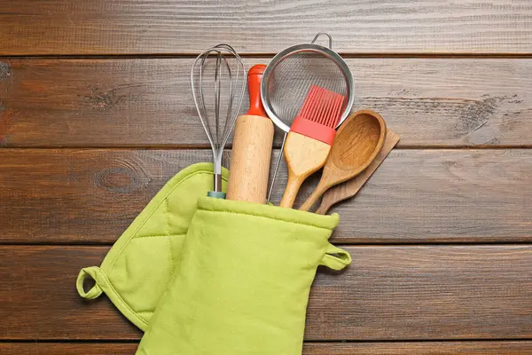 Farklı mutfak aletleri fırın eldiveni ahşap masa, üst görünüm
