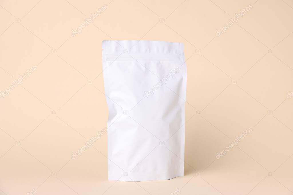 One zipper stand-up pouch on beige background. Mockup for design