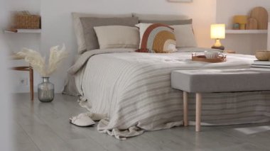 Odasında yumuşak çarşaflar olan rahat bir yatak, kamera sağa hareket ediyor. Ev tekstili