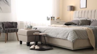 Odasında yumuşak çarşaflar ve battaniyeler olan rahat bir yatak, kamera sağa doğru hareket ediyor. Ev tekstili