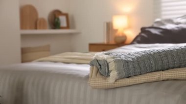 Ev yapımı. Odasında yumuşak çarşaflar ve battaniyeler olan rahat bir yatak, yakın plan. Kamera sağa hareket ediyor