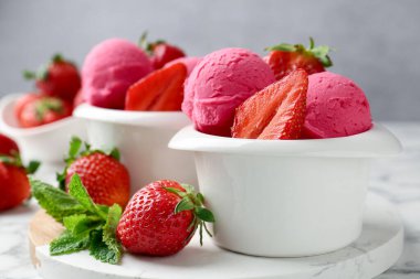 Tazeleyici şerbet, çilek ve nane şekeri beyaz mermer masada gri arka planda, yakın plan