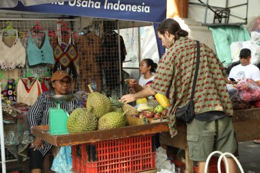 Bali, Endonezya - 25 Mayıs 2025: Turist açık hava pazarından egzotik meyveler alıyor