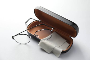 Şık gözlüklü çanta ve açık arkaplanda temizlik bezi.