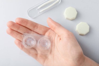 Kontakt lensleri açık arkaplanda, düz uzanan kadın