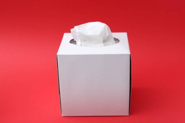 Kırmızı arkaplanda kağıt mendilli kutu