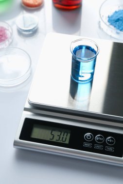 Beyaz arka planda, örnek kabı ve diğer laboratuvar ekipmanlarıyla ölçeklendir, kapat