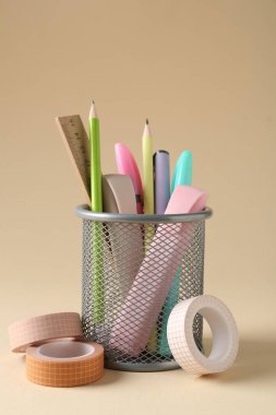 Bej arkaplanda kalem tutacağında farklı kırtasiye