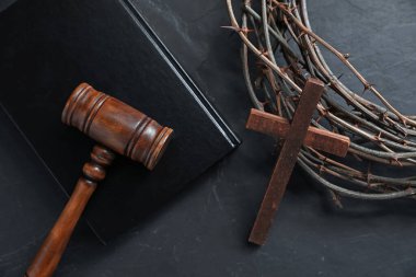 Yargıç tokmağı, dikenli taç, İncil ve ahşap haç siyah masada, düz yatıyordu.