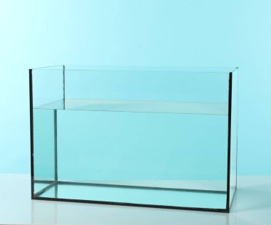 Beyaz masada turkuaz arka planda su bulunan cam akvaryum