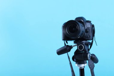 Açık mavi arkaplanda profesyonel video kamera, metin için boşluk