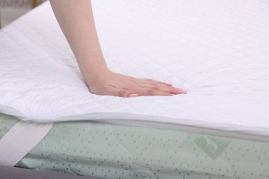 Yatakta yumuşak yatağa dokunan kadın, yakın plan.