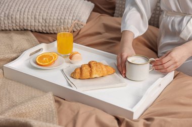 Kadın yatakta nefis bir kahvaltı yapıyor, yakın plan.