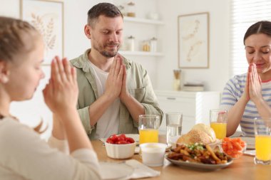 Aile akşam yemeğinden önce evde dua ediyor.