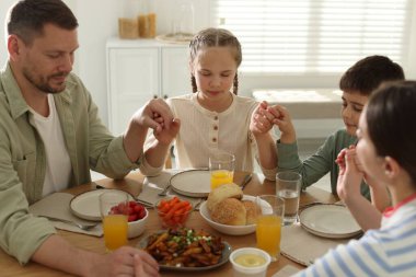 Aile akşam yemeğinden önce evde dua ediyor.