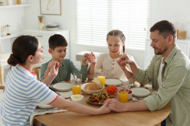 Aile akşam yemeğinden önce evde dua ediyor.
