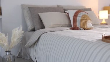 Odasında yumuşak çarşaflar olan rahat bir yatak, kamera sağa hareket ediyor. Ev tekstili