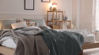 Yumuşak çarşafları ve odada battaniyeleri olan rahat bir yatak, kamera hareket ediyor. Ev tekstili