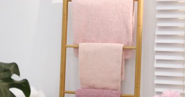 Banyodaki dekoratif ahşap merdivende yumuşak havlular, aşağı inen kamera.