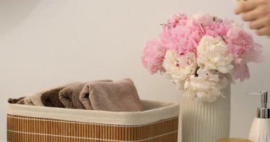 İçerideki depoya havlu koyan kadın, yakın plan.