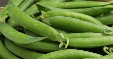 Arka plan olarak taze bezelye kabukları yığını, yakın plan