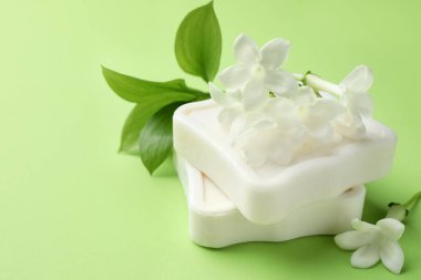 Açık yeşil arka planda sabun ve yasemin çiçekleri, yakın plan. Metin için boşluk