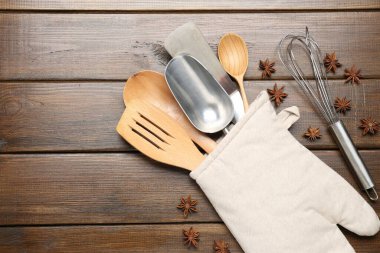 Fırın eldiveninde farklı mutfak aletleri ve ahşap masada anason yıldızları.