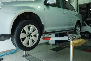 Araba servisinde lastik değiştirirken otomobili kaldırmış.
