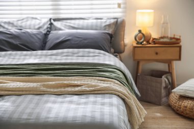 Odasında yumuşak çarşaflar ve battaniyeler olan rahat bir yatak, yakın plan. Ev tekstili