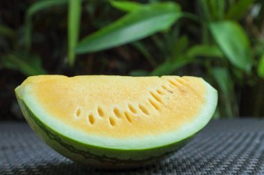 Dışarıdaki hasır masada leziz bir karpuz dilimi, yakın plan.