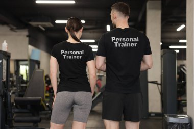 Spor salonunda üzerinde yazılar olan tişörtler giyen spor ayakkabıları. Arka plan