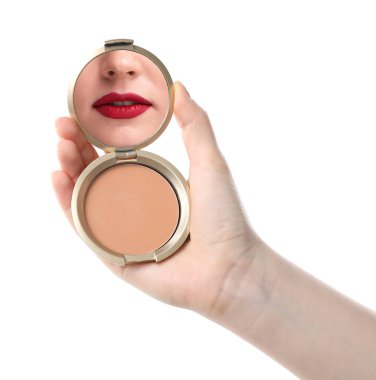 Kırmızı dudaklı güzel kadın beyaz arka planda pudra aynasına bakıyor, yakın plan.