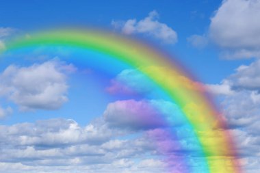 Mavi gökyüzünde parlak gökkuşağı güneşli bir günde bulutlarla