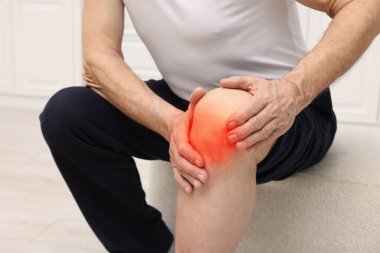 Evde dizinde ağrıdan muzdarip son sınıf öğrencisi, yakın plan.