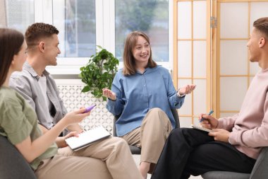 Yaşam koçluğu dersinde kapalı alanda toplantı yapan bir grup insan.