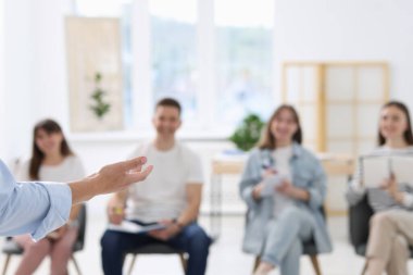 Yaşam koçluğu dersinde toplanan bir grup insan kapalı alanlarda seçici bir şekilde odaklanıyor.