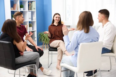 Yaşam koçluğu dersinde kapalı alanda toplantı yapan bir grup insan.