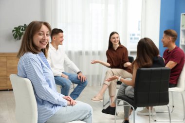 Yaşam koçluğu dersinde toplanan bir grup insan kapalı alanlarda seçici bir şekilde odaklanıyor.