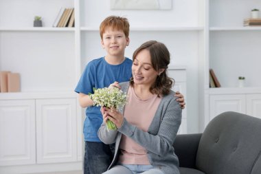 Çocuk, annesine vadideki güzel çiçekleri veriyor.