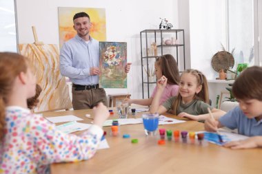 Evde resim dersinde öğretmenleri olan çocuklar. Çizim yapmayı öğrenmek