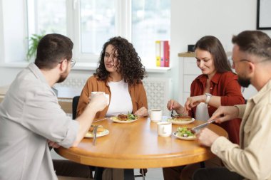 İş arkadaşları öğle arasında ofiste sohbet ediyorlar.