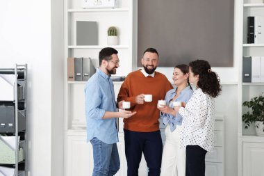 Ofiste kahve molası sırasında iş arkadaşları sohbet ediyor.