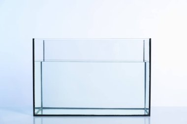 Beyaz zemin üzerinde su olan cam akvaryum