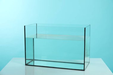 Beyaz masada turkuaz arka planda su bulunan cam akvaryum