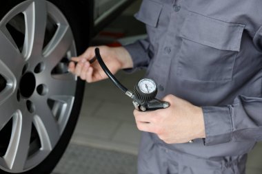 Tamirci araba servisinde yeni lastik şişiriyor, yakın plan.