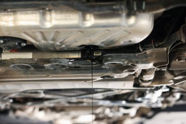 Araba motorundan damlayan eski kirli motor yağı atölyede, yakın plan.