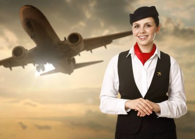 Gün batımına karşı gülen hostes uçak ve bulutlarla